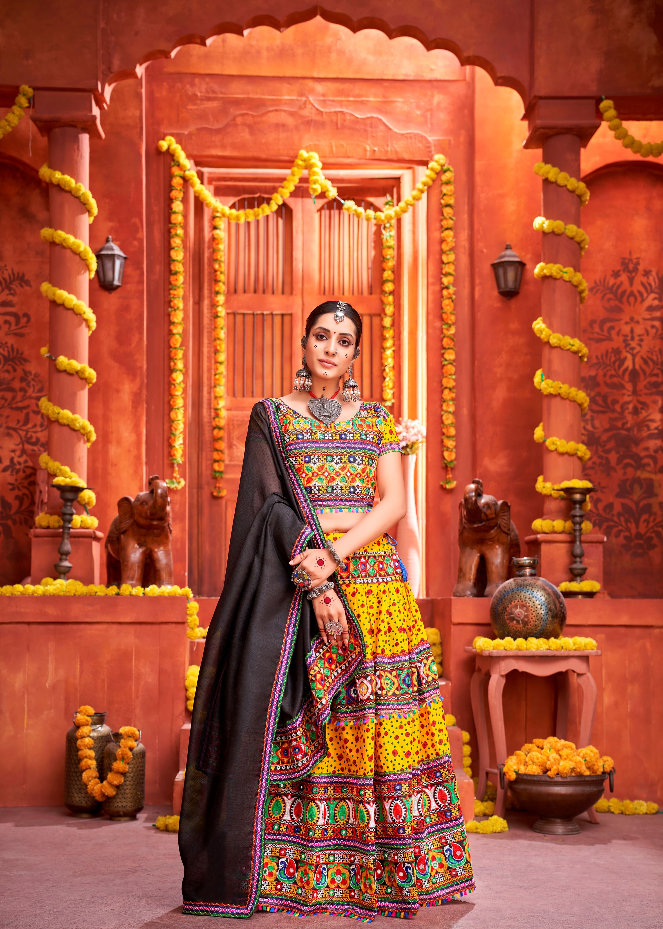 Yellow And Black Navratri Chaniya Choli With Patola Print And Gamthi Work And Real Mirror Work